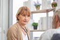 Female doctor visiting elderly man at home, Health visitor, and a senior man during home visit Royalty Free Stock Photo