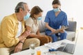 Female doctor visiting senior couple at home, wearing face masks during flu outbreak, talking about their treatment Royalty Free Stock Photo