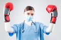 Female doctor wearing red boxing gloves celebrating with arms raised Royalty Free Stock Photo