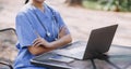 Female Doctor Wearing Scrubs In Hospital Corridor Using Digital Tablet Royalty Free Stock Photo