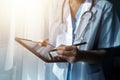 Female Doctor Wearing Scrubs In Hospital Corridor Using Digital Tablet Royalty Free Stock Photo