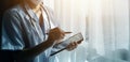 Female Doctor Wearing Scrubs In Hospital Corridor Using Digital Tablet Royalty Free Stock Photo