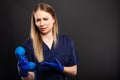 Female doctor wearing scrubs looking confused holding telephone Royalty Free Stock Photo