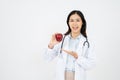 Female doctor with a white coat smiling and holding an apple Royalty Free Stock Photo