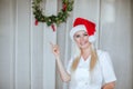 Female doctor in white medical smock and santa`s cap posing on white background