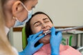 The female doctor in white uniform treats the teeth with caries of a young woman with a drill Royalty Free Stock Photo