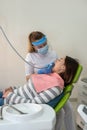 The female doctor in white uniform treats the teeth with caries of a young woman with a drill Royalty Free Stock Photo