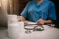 Female doctor working on desk with laptop computer and paperwork in the office. Royalty Free Stock Photo