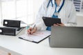 Female doctor working on desk with tablet, laptop computer and paperwork in the office. Medical and doctor concept Royalty Free Stock Photo