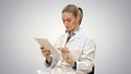Female doctor working on digital tablet on white background.