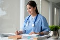 A female doctor working on her medical cases at her desk in the office at a hospital Royalty Free Stock Photo