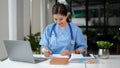 A female doctor working on her medical cases and reading a medical research on her laptop Royalty Free Stock Photo