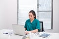 A female doctor working on medical expertise while sitting at desk in front of laptop Royalty Free Stock Photo