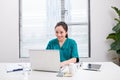 A female doctor working on medical expertise while sitting at desk in front of laptop Royalty Free Stock Photo