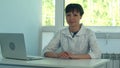 Female doctor working at office desk with laptop and smiling at camera Royalty Free Stock Photo