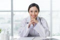 Female doctor working at office desk and smiling Royalty Free Stock Photo