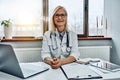 Female doctor working at office desk, she is smiling at camera, healthcare professionals Royalty Free Stock Photo