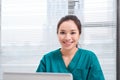 Female doctor working at office desk and smiling at camera, office interior Royalty Free Stock Photo