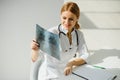 Female doctor working at office desk and smiling, office interior on background. Royalty Free Stock Photo