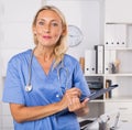 Female doctor writing notes on clipboard in clinic Royalty Free Stock Photo