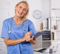 Female doctor writing notes on clipboard in clinic Royalty Free Stock Photo