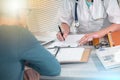Female doctor writing prescription to her patient; multiple exposure Royalty Free Stock Photo