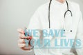 Female doctor writing text we save your lives. Healthcare, saving life, medical concept Royalty Free Stock Photo