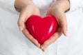 Female doctors's hands holding and covering red heart Royalty Free Stock Photo