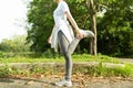 Female doing stretching exercise for legs, Young fitness healthy woman warm up before running or jogging in the park in sunshine Royalty Free Stock Photo