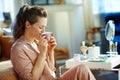 Female drinking espresso at modern home in sunny winter day