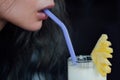 Female drinking pineapple cocktail. Piece of fruit and straw, a close-up mouth and a glass. Royalty Free Stock Photo