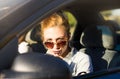 Female driver applying lipstick in a car Royalty Free Stock Photo