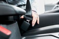 Female driver fastens seat belt close-up