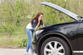Female driver phoning for help after a breakdown