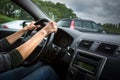 Female driver`s hands driving a car on a highway