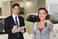 Female driver showing a key after bying a new car