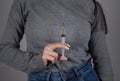 Female drug addict hand syringe. Gray background