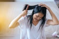 Female drying long hair with dryer,Young asian woman after bath hairbrushing her hair with comb Royalty Free Stock Photo