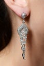 Female ear in jewelry earrings Royalty Free Stock Photo