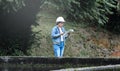 Female ecologist in safety hat working and controlling a quality of water at wastewater treatment plant. Environmental engineers Royalty Free Stock Photo