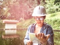 Female ecologist in safety hat working and controlling a quality of water at wastewater treatment plant. Environmental engineers Royalty Free Stock Photo