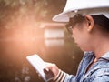 Female ecologist in safety hat working with a smart phone and controlling a quality of water at wastewater treatment plant. Royalty Free Stock Photo