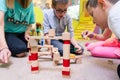 Female educator teaching children to build a train circuit