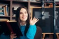 Female Educator Teaching Online Course Holding a Book