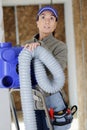 female elctrician fitting air conditions pipe in building ceiling Royalty Free Stock Photo