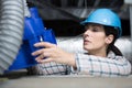 female elctrician fitting air conditions pipe in building ceiling Royalty Free Stock Photo