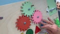 Female elderly women spin colorful wooden circles on a board to restore motility after a previous illness