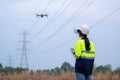 A female electrical engineer fielding wearing vr goggles using drone to inspect power station to view power plant planning work,