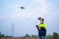 A female electrical engineer wearing vr goggles using drone to inspect power station to explore power poles in aerial view,