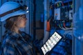 Female electrician adjusts breakers in a control cabinet. Panel setup. Royalty Free Stock Photo